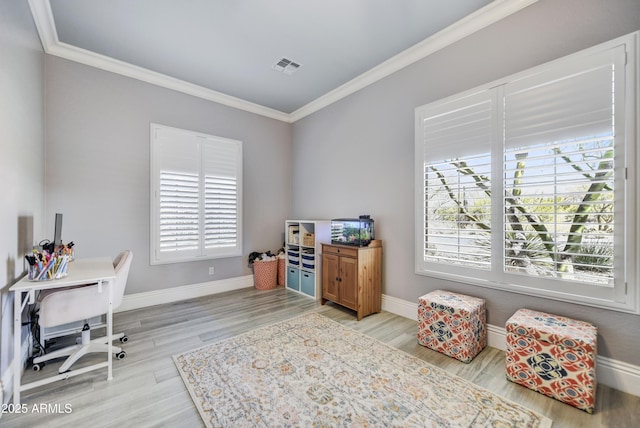 office area featuring crown molding, healthy amount of natural light, baseboards, and light wood-style floors