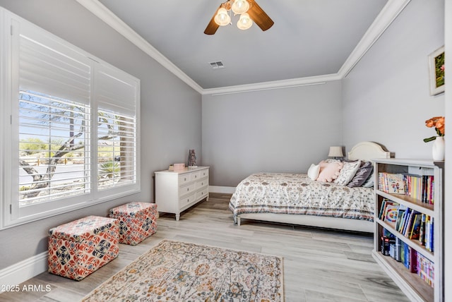 bedroom featuring crown molding, wood finished floors, baseboards, and ceiling fan