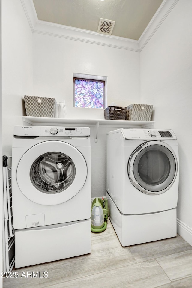 washroom with crown molding and washer and dryer