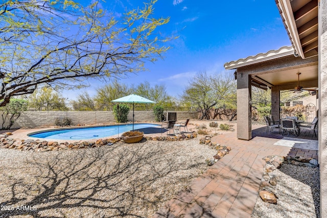 view of swimming pool featuring ceiling fan, a fenced backyard, and a patio area