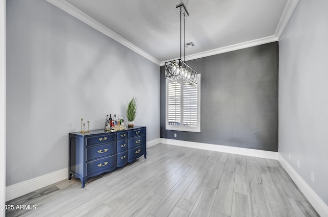 dining space with crown molding, light wood-type flooring, baseboards, and a chandelier