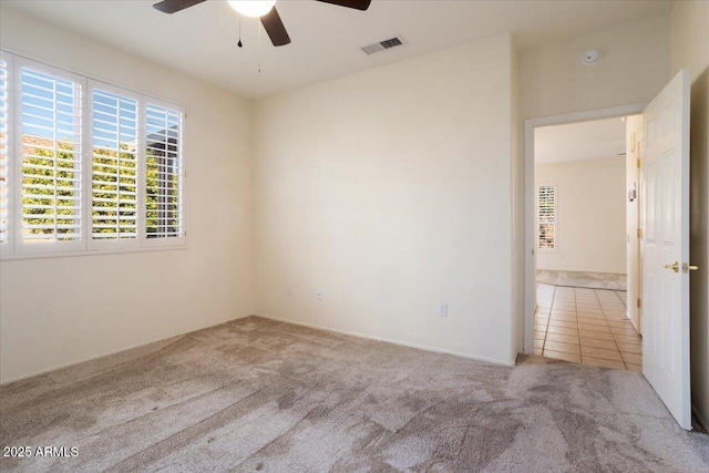 carpeted spare room with ceiling fan