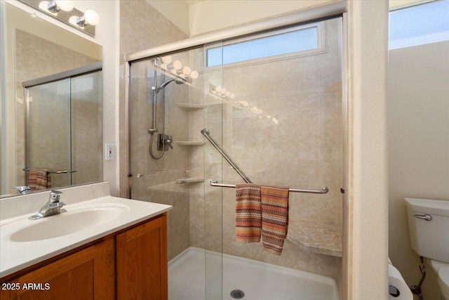 bathroom featuring vanity, an enclosed shower, and toilet