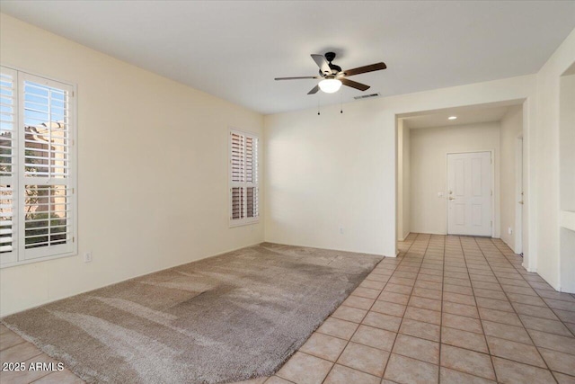 carpeted spare room with ceiling fan