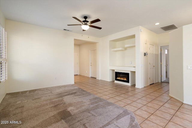 unfurnished living room featuring light tile patterned flooring and ceiling fan