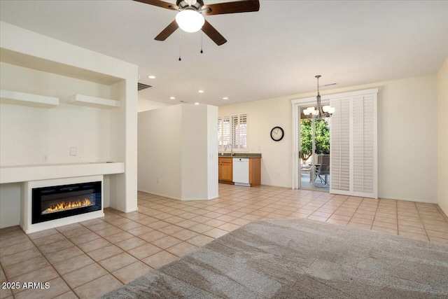 unfurnished living room with light tile patterned floors, ceiling fan with notable chandelier, and sink