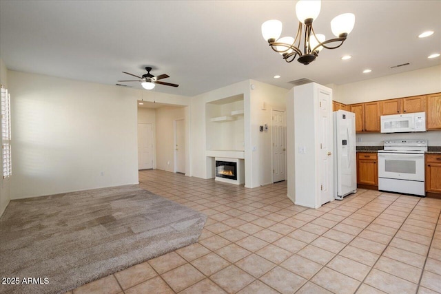 kitchen with light tile patterned flooring, white appliances, and ceiling fan with notable chandelier