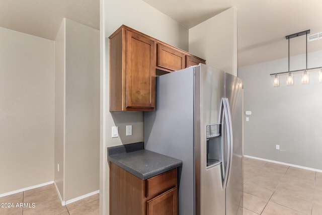 kitchen featuring pendant lighting, light tile patterned floors, and stainless steel fridge with ice dispenser