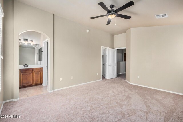 carpeted spare room featuring ceiling fan and vaulted ceiling