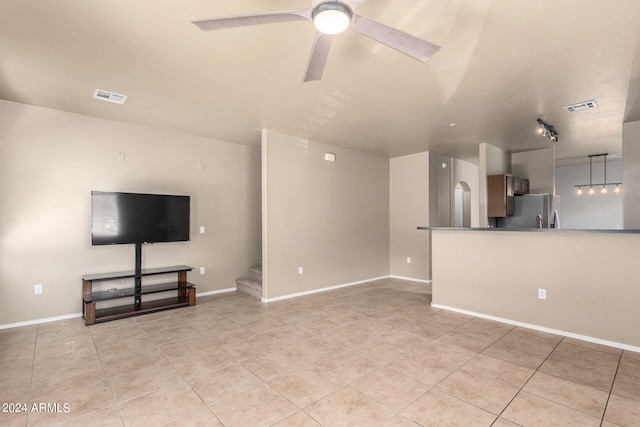 unfurnished living room featuring ceiling fan and light tile patterned flooring