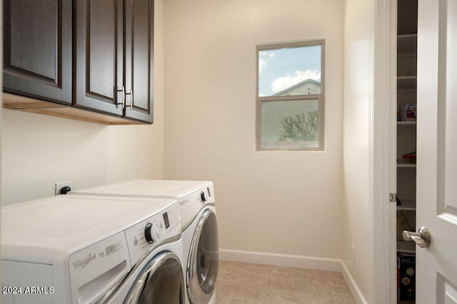 laundry room with washer and clothes dryer, light tile patterned floors, and cabinets