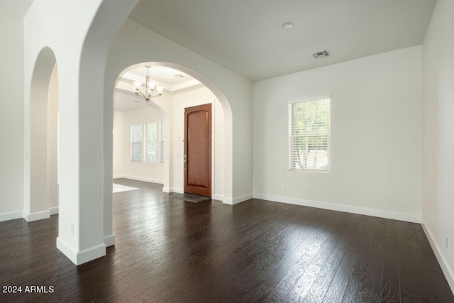 unfurnished room with dark hardwood / wood-style floors and a chandelier