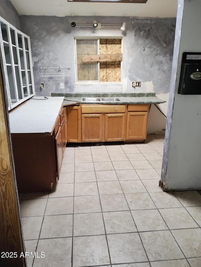 kitchen with backsplash, sink, and light tile patterned flooring