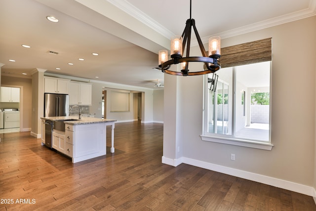 1505 W Orangewood Ave W, Phoenix, AZ 85021 - kitchen featuring washing machine and dryer, ornamental molding, a chandelier, white cabinetry, and open floor plan