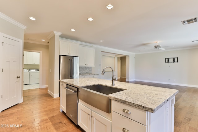 1505 W Orangewood Ave W, Phoenix, AZ 85021 - kitchen featuring appliances with stainless steel finishes, washer and clothes dryer, crown molding, recessed lighting, and a ceiling fan