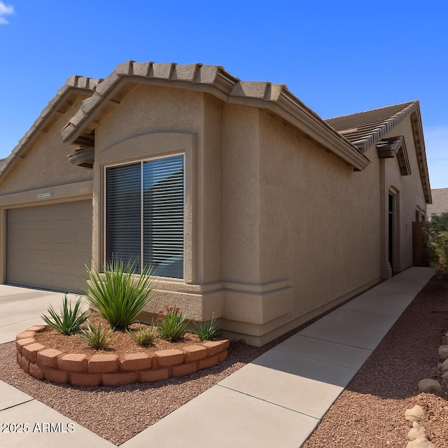6610 E University Dr Unit 127, Mesa, AZ 85205 - view of home's exterior featuring stucco siding, a garage, and concrete driveway