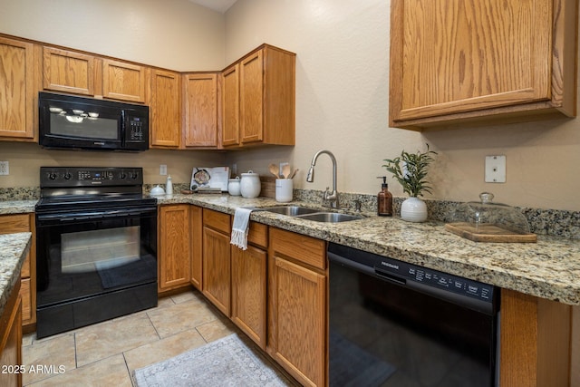6610 E University Dr Unit 127, Mesa, AZ 85205 - kitchen with black appliances, brown cabinetry, light tile patterned floors, and light stone countertops