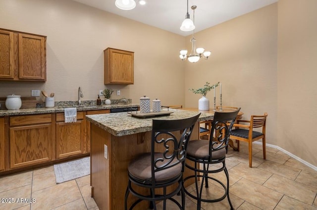 6610 E University Dr Unit 127, Mesa, AZ 85205 - kitchen with brown cabinetry, a center island, a kitchen bar, and light tile patterned floors