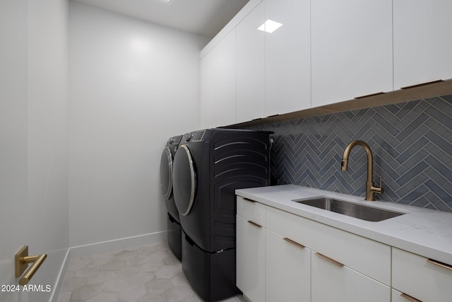 laundry area featuring sink, washer and dryer, cabinets, and light tile floors