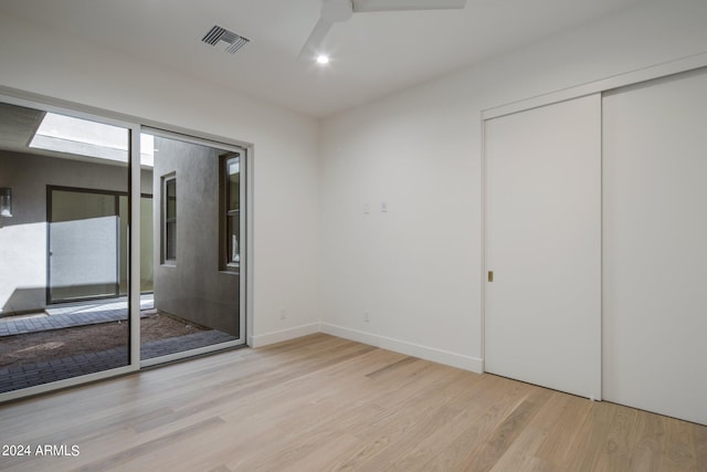 unfurnished bedroom featuring ceiling fan, a closet, and light hardwood / wood-style flooring