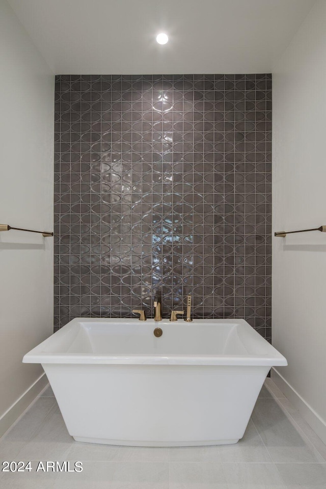 bathroom with tile flooring and a washtub