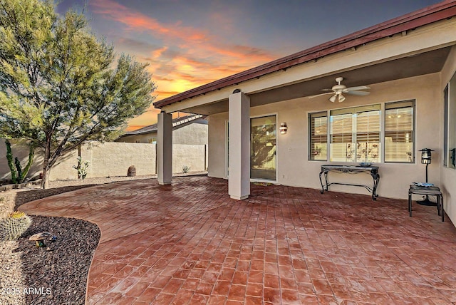 patio terrace at dusk featuring ceiling fan