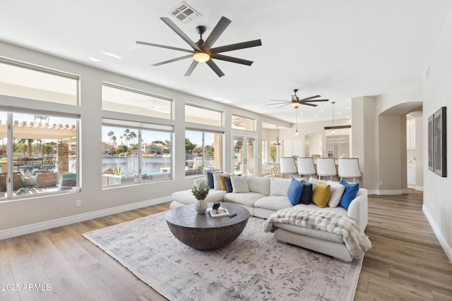 living room featuring a healthy amount of sunlight, visible vents, and wood finished floors