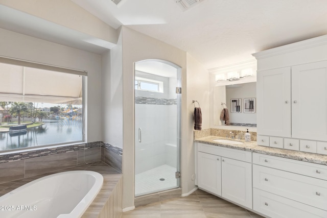 bathroom with visible vents, a garden tub, a shower stall, and vanity