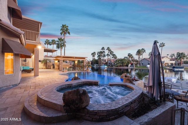 view of pool with a water view, a patio area, an infinity pool, and an in ground hot tub