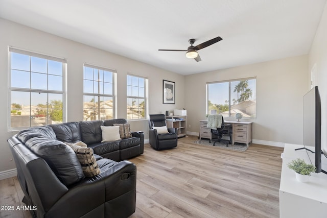 living room featuring light wood-type flooring, baseboards, and a ceiling fan