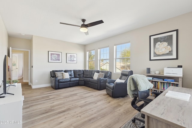 living area with ceiling fan, light wood-style flooring, and baseboards