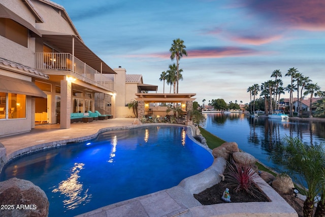 view of swimming pool featuring an infinity pool, a patio area, and a water view