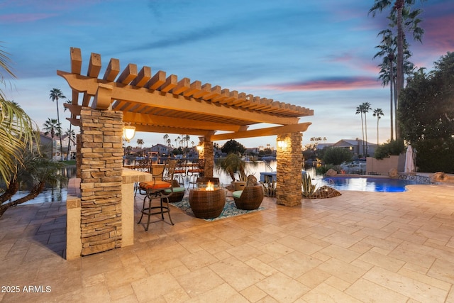 patio terrace at dusk featuring an outdoor fire pit, an outdoor pool, and a pergola