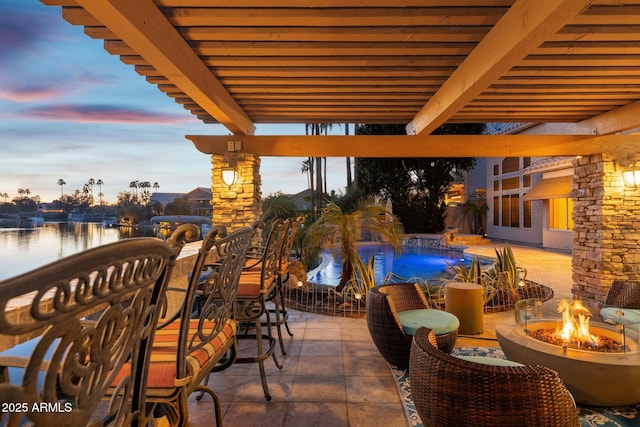 exterior space featuring an outdoor fire pit, a water view, and an outdoor pool