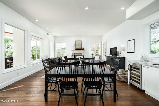 6556 N Arizona Biltmore Cir, Phoenix, AZ 85016 - dining space with recessed lighting, baseboards, dark wood finished floors, beverage cooler, and a fireplace