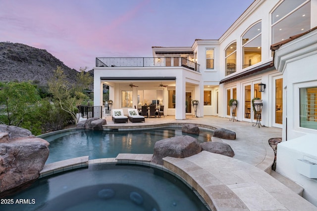 6556 N Arizona Biltmore Cir, Phoenix, AZ 85016 - pool at dusk featuring an outdoor hangout area, a pool with connected hot tub, a patio, a ceiling fan, and a mountain view