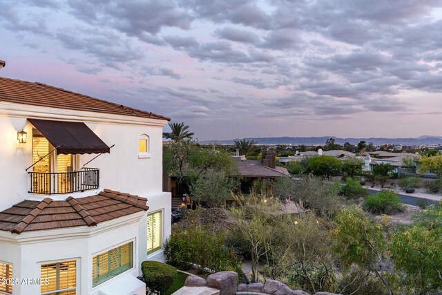 6556 N Arizona Biltmore Cir, Phoenix, AZ 85016 - property exterior at dusk featuring a balcony, a tile roof, and stucco siding
