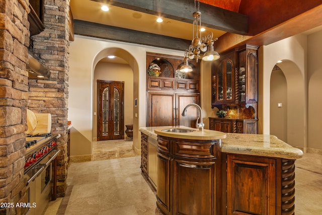 bar featuring arched walkways, beam ceiling, pendant lighting, a sink, and baseboards