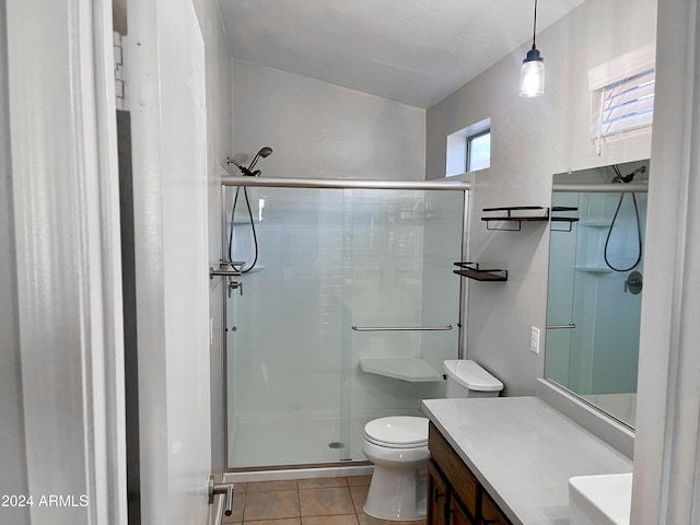 bathroom with tile patterned flooring, vanity, toilet, and an enclosed shower