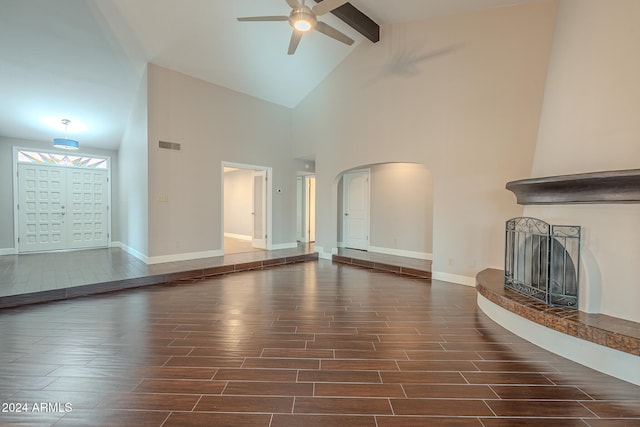 unfurnished living room featuring beamed ceiling, ceiling fan, dark hardwood / wood-style flooring, and high vaulted ceiling