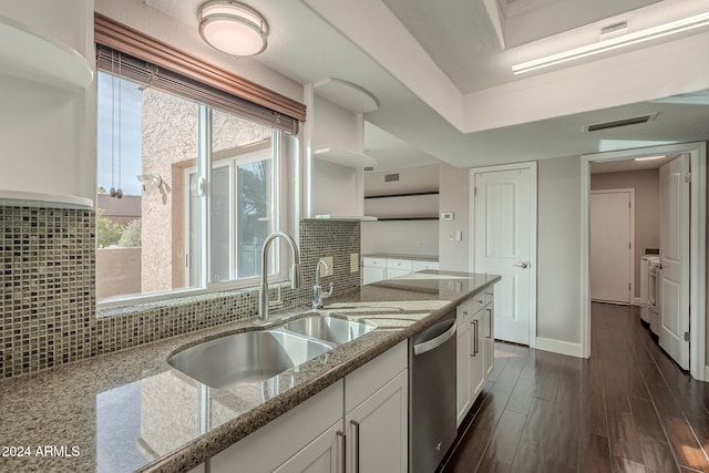 kitchen with decorative backsplash, white cabinets, light stone counters, and dishwasher