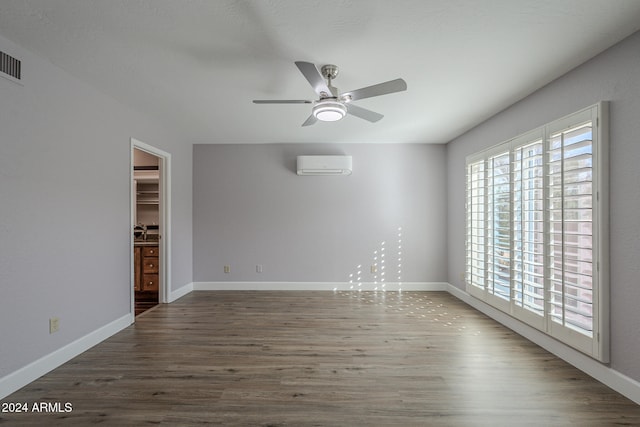 empty room featuring a wall mounted air conditioner, ceiling fan, wood-type flooring, and sink