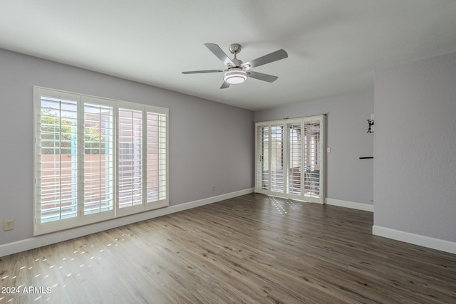 spare room featuring ceiling fan, dark hardwood / wood-style flooring, and a healthy amount of sunlight