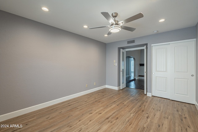 unfurnished bedroom featuring a closet, light hardwood / wood-style flooring, and ceiling fan