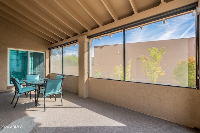 sunroom / solarium with vaulted ceiling with beams