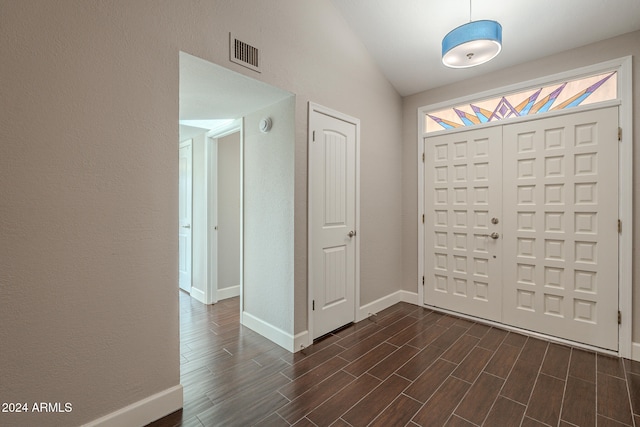 entryway with dark hardwood / wood-style flooring and lofted ceiling