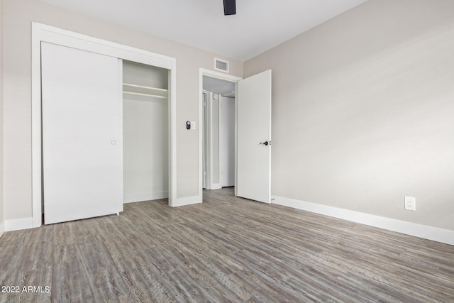 unfurnished bedroom featuring a closet and dark wood-type flooring