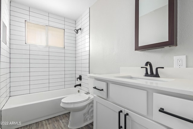 full bathroom with vanity, toilet, hardwood / wood-style flooring, and tiled shower / bath