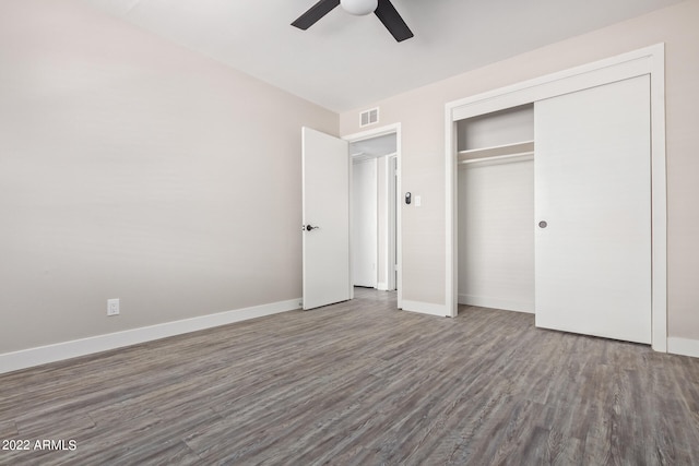 unfurnished bedroom with a closet, wood-type flooring, and ceiling fan