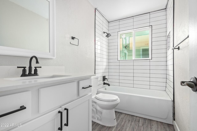 full bathroom featuring vanity, tiled shower / bath combo, toilet, and hardwood / wood-style flooring